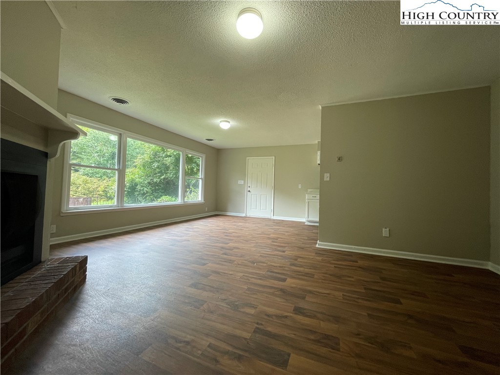 274 Bryan Davis Road Creston, NC 28615 - Photo 21 of 29 an empty room with wooden floor and windows