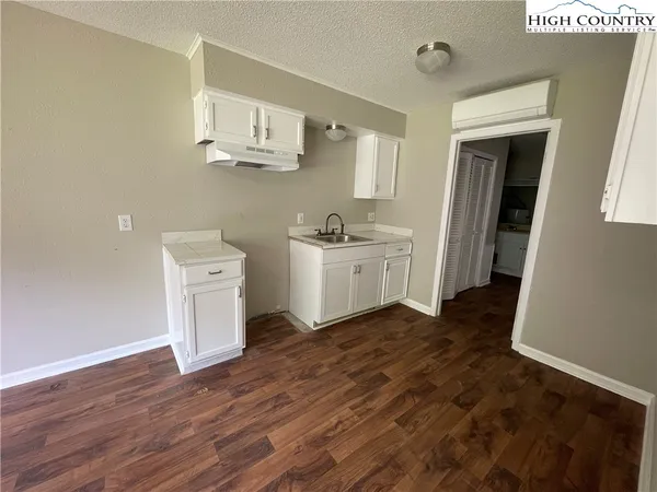 a kitchen with a wooden floor and electronic appliances