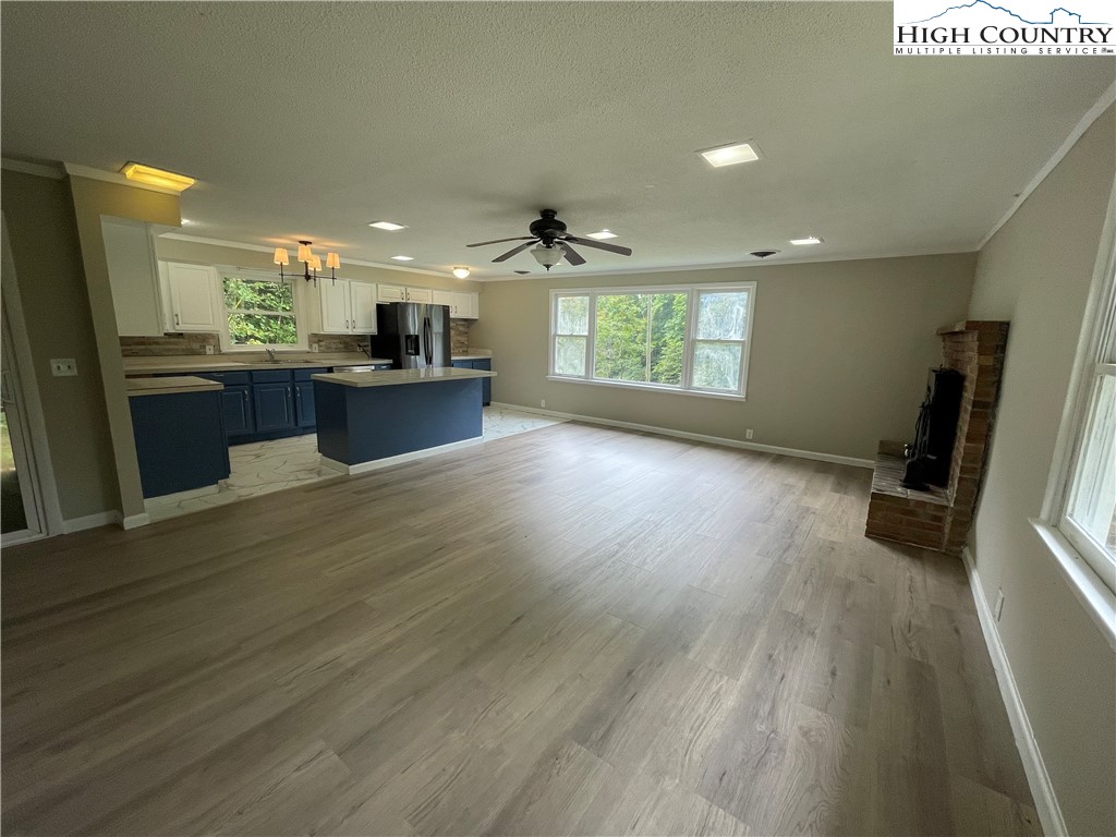 274 Bryan Davis Road Creston, NC 28615 - Photo 10 of 29 a open kitchen with stainless steel appliances kitchen island granite countertop a sink dishwasher a refrigerator and a stove with wooden floor