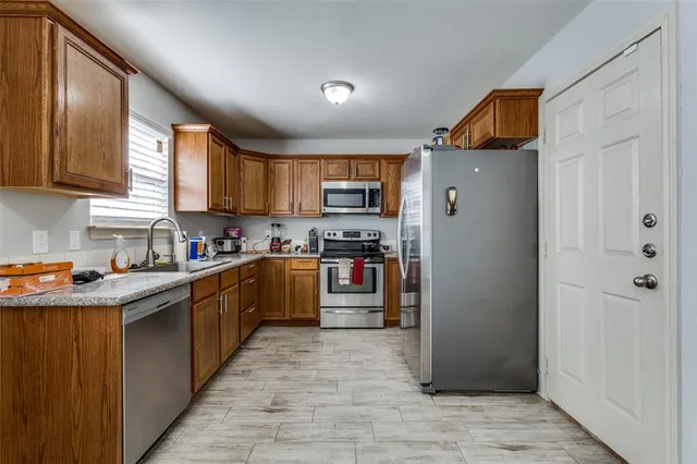 a kitchen with stainless steel appliances granite countertop a refrigerator and a stove top oven