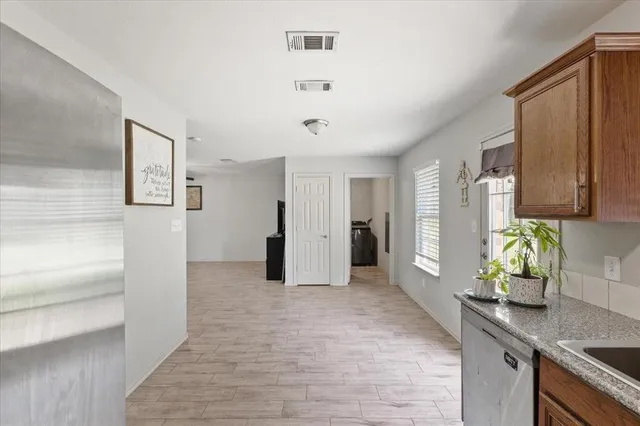 a kitchen with stainless steel appliances granite countertop a refrigerator and a stove top oven