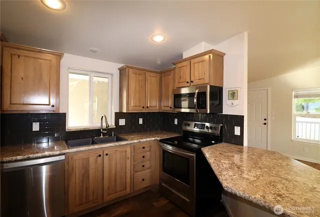a kitchen with stainless steel appliances granite countertop a sink stove and refrigerator