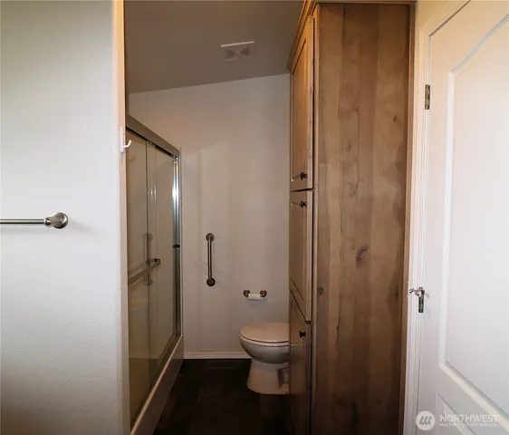 a bathroom with a granite countertop toilet a sink and shower