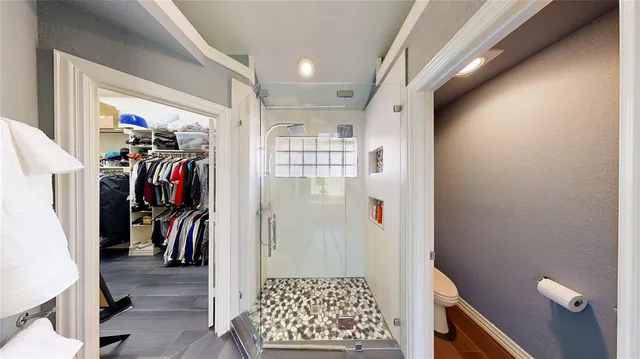 a view of walk in closet with clothes and shoes