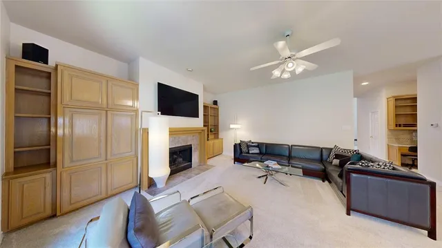 a living room with furniture large windows and wooden floor