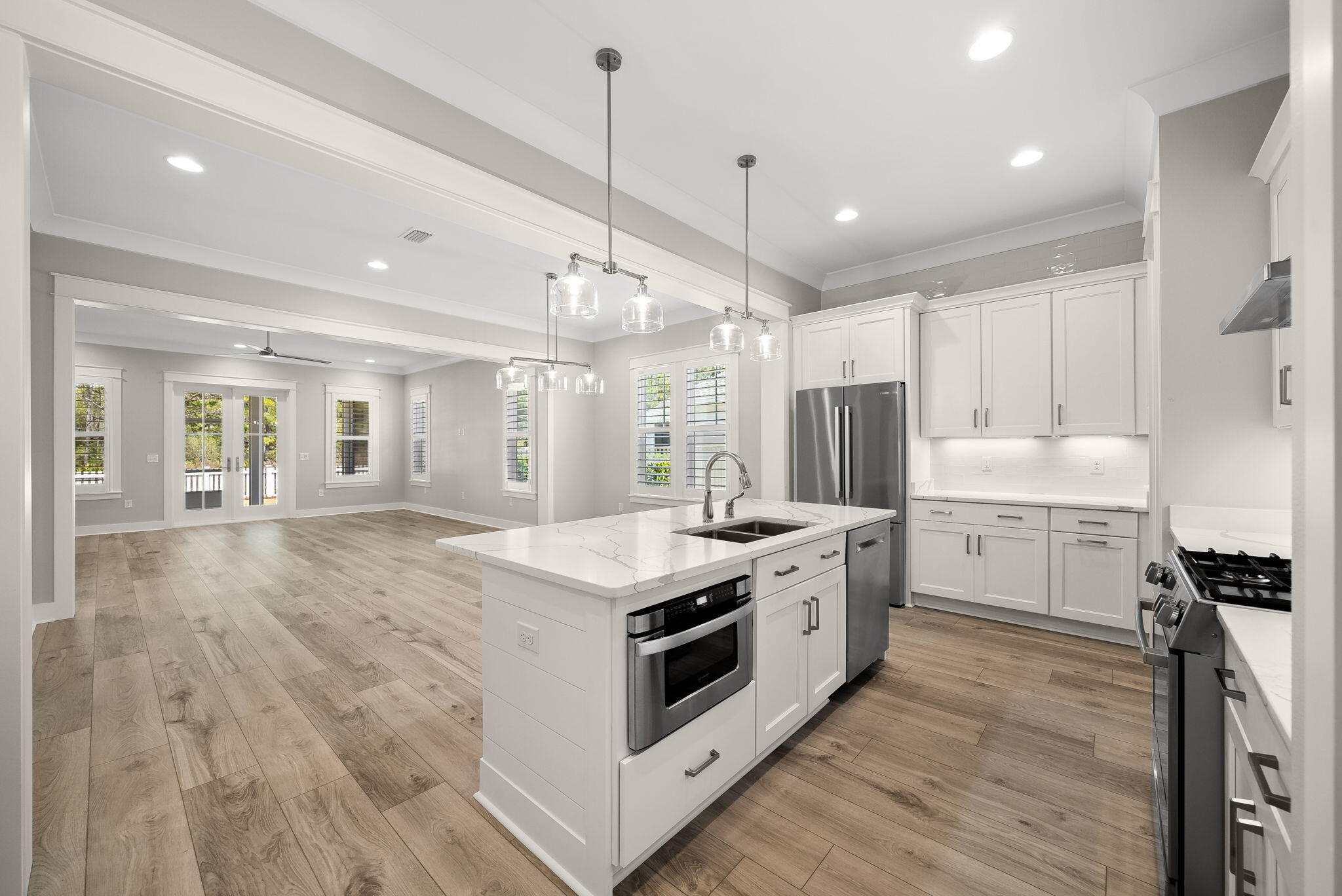 64 West Firethorn Circle Watersound, FL 32461 - Photo 11 of 63 a kitchen with a stove a sink a center island and wooden floor