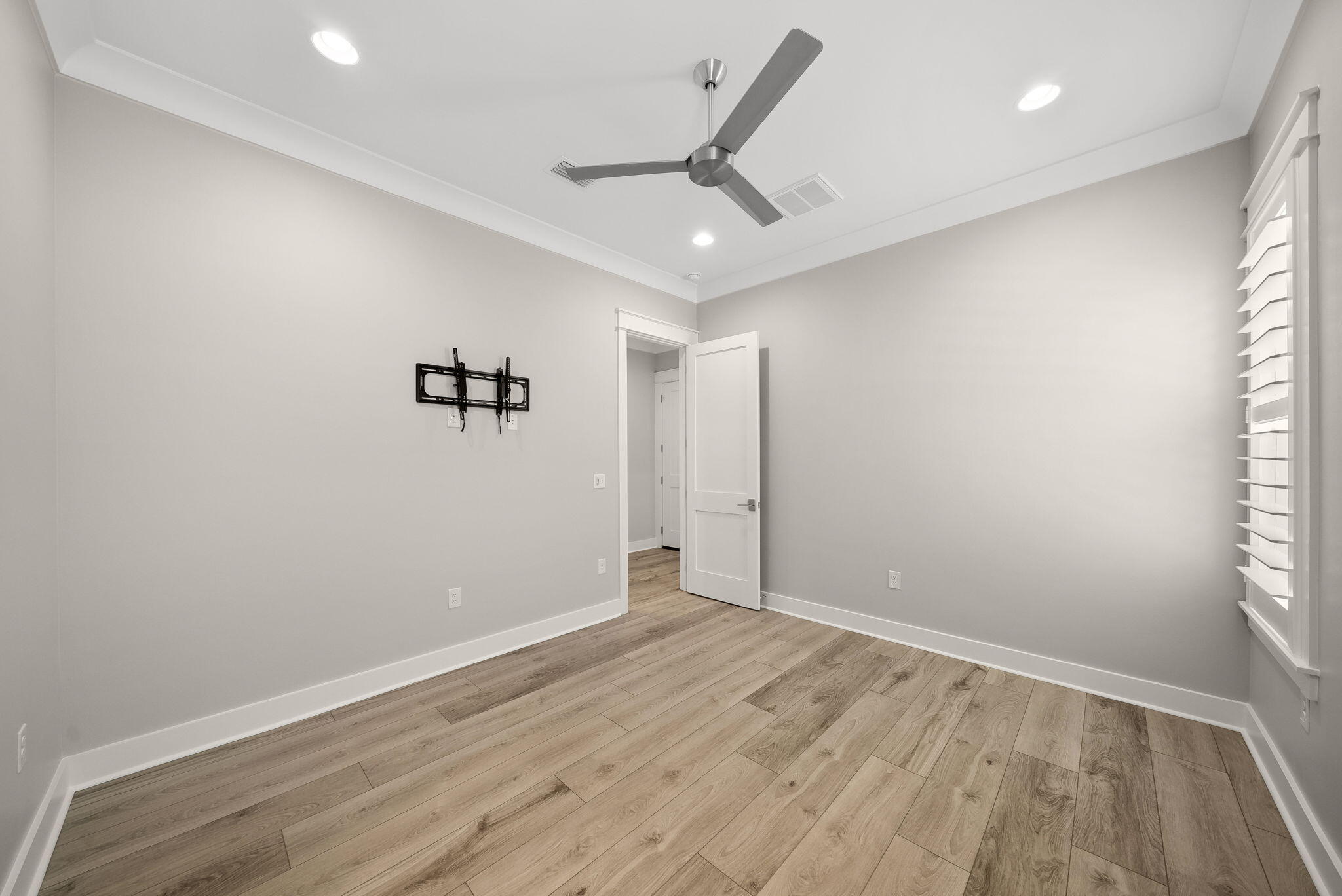 64 West Firethorn Circle Watersound, FL 32461 - Photo 27 of 63 an empty room with a ceiling fan and wooden floor