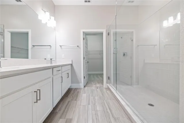 a spacious bathroom with a shower sink and mirror