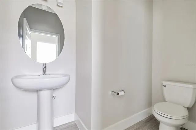 a bathroom with a toilet a sink and mirror