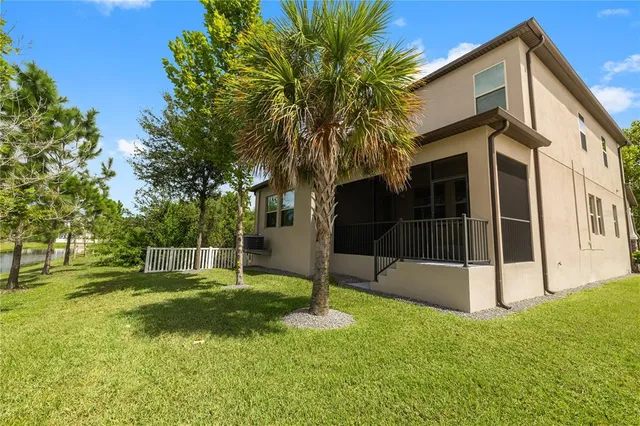 a view of a backyard with wooden fence and a large tree