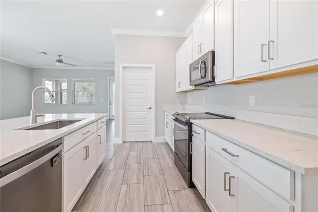a kitchen with granite countertop white cabinets and white appliances