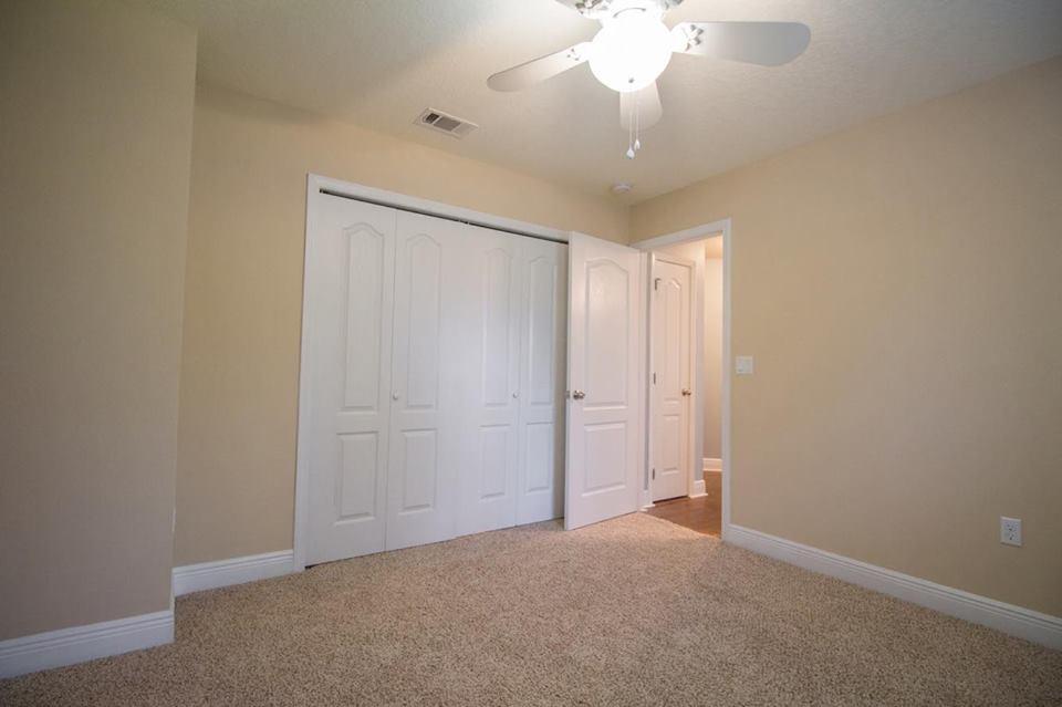 4500 Hermosa Road Crestview, FL 32539 - Photo 15 of 27 an empty room with a chandelier fan and windows