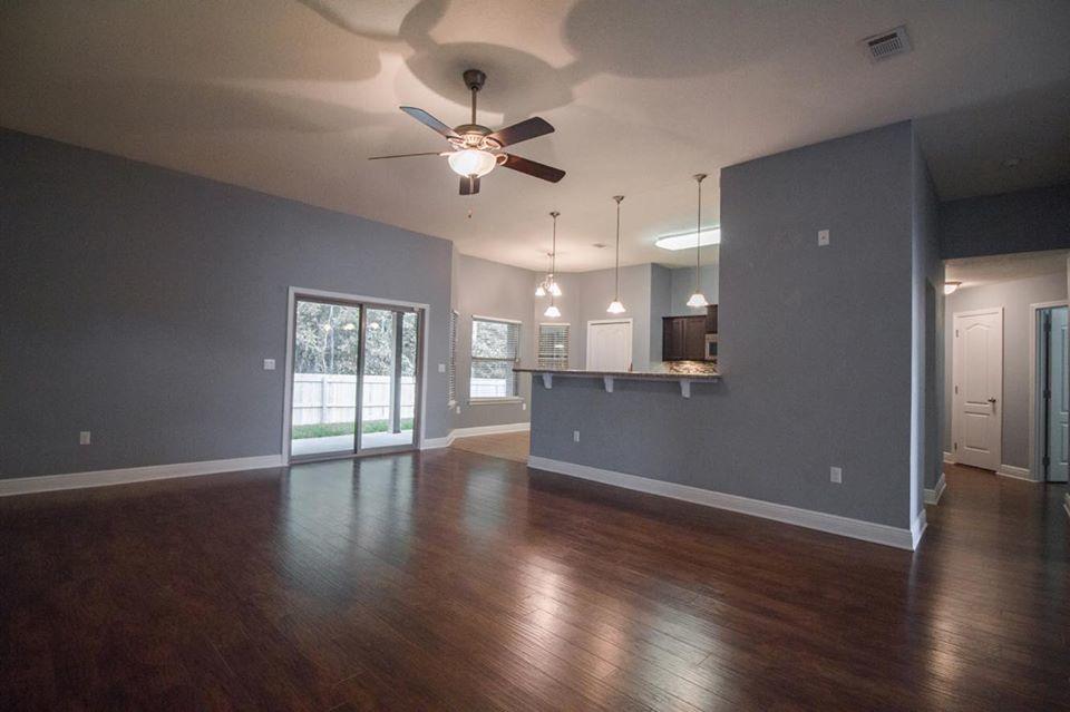 4500 Hermosa Road Crestview, FL 32539 - Photo 6 of 27 a view of an empty room with wooden floor and a kitchen