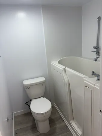 a white toilet sitting next to a bath tub