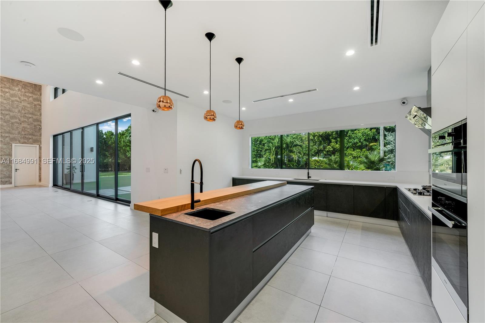 6695 Southwest 112th Street Pinecrest, FL 33156 - Photo 42 of 99 a kitchen with stainless steel appliances granite countertop a sink and a stove