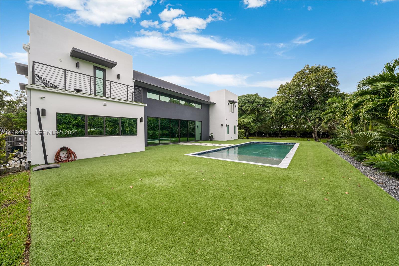 6695 Southwest 112th Street Pinecrest, FL 33156 - Photo 93 of 99 a view of a swimming pool with a yard