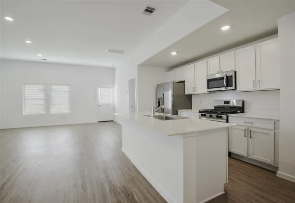 a kitchen with stainless steel appliances granite countertop a stove a sink and a refrigerator