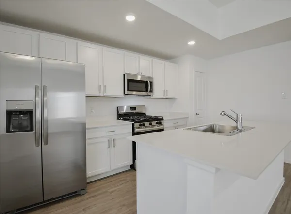 a kitchen with appliances a sink and cabinets