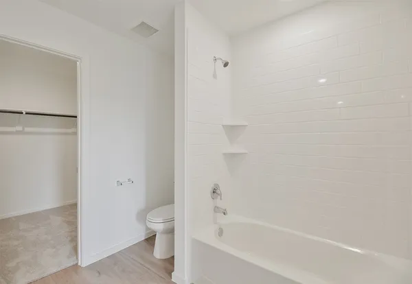 a bathroom with a granite countertop bathtub shower and toilet