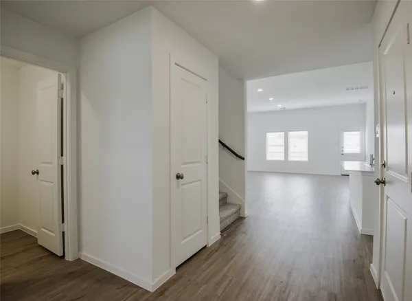 a view of a hallway with wooden floor and closet area