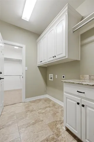 a kitchen with white cabinets and a refrigerator