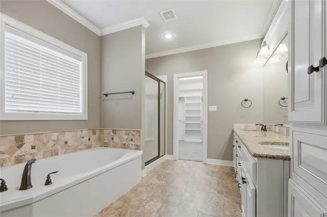 a bathroom with a tub a sink and a large mirror