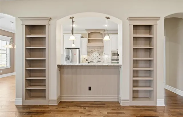 a view of cabinet with wooden floor and kitchen view
