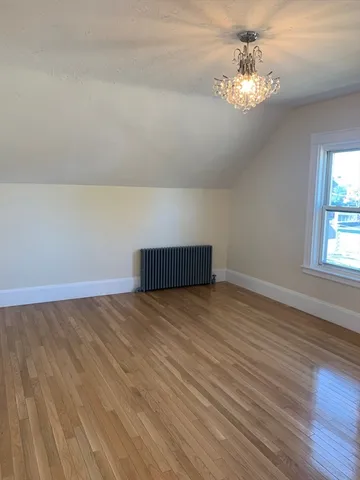 a view of empty room with wooden floor and window