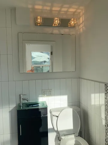 a bathroom with a toilet sink and mirror