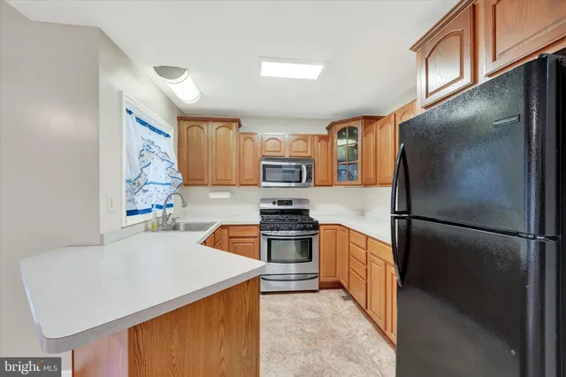 a kitchen with stainless steel appliances granite countertop a refrigerator sink stove and oven