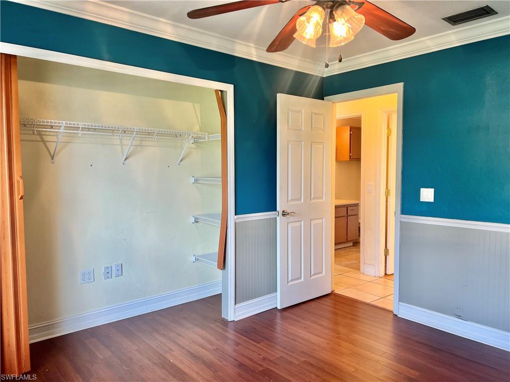 18581 Tampa Road Fort Myers, FL 33967 - Photo 20 of 25 Unfurnished bedroom featuring hardwood / wood-style floors, ceiling fan, ornamental molding, and a closet