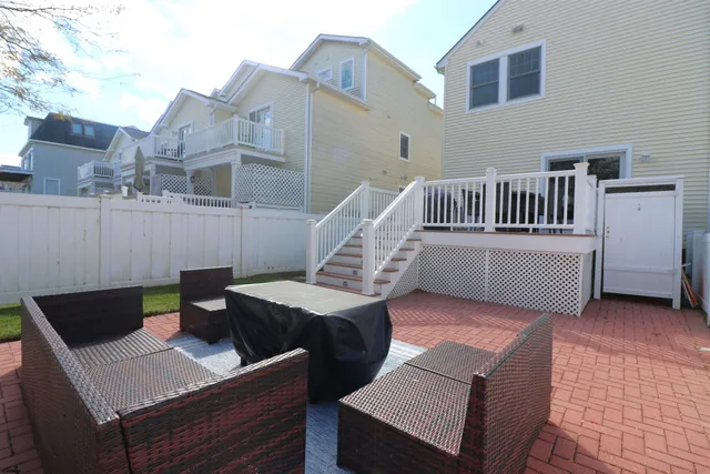 a view of a deck with couches chairs and wooden floor