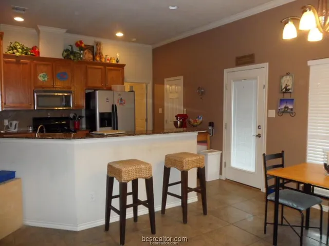 a living room with stainless steel appliances kitchen island granite countertop furniture and a view of kitchen