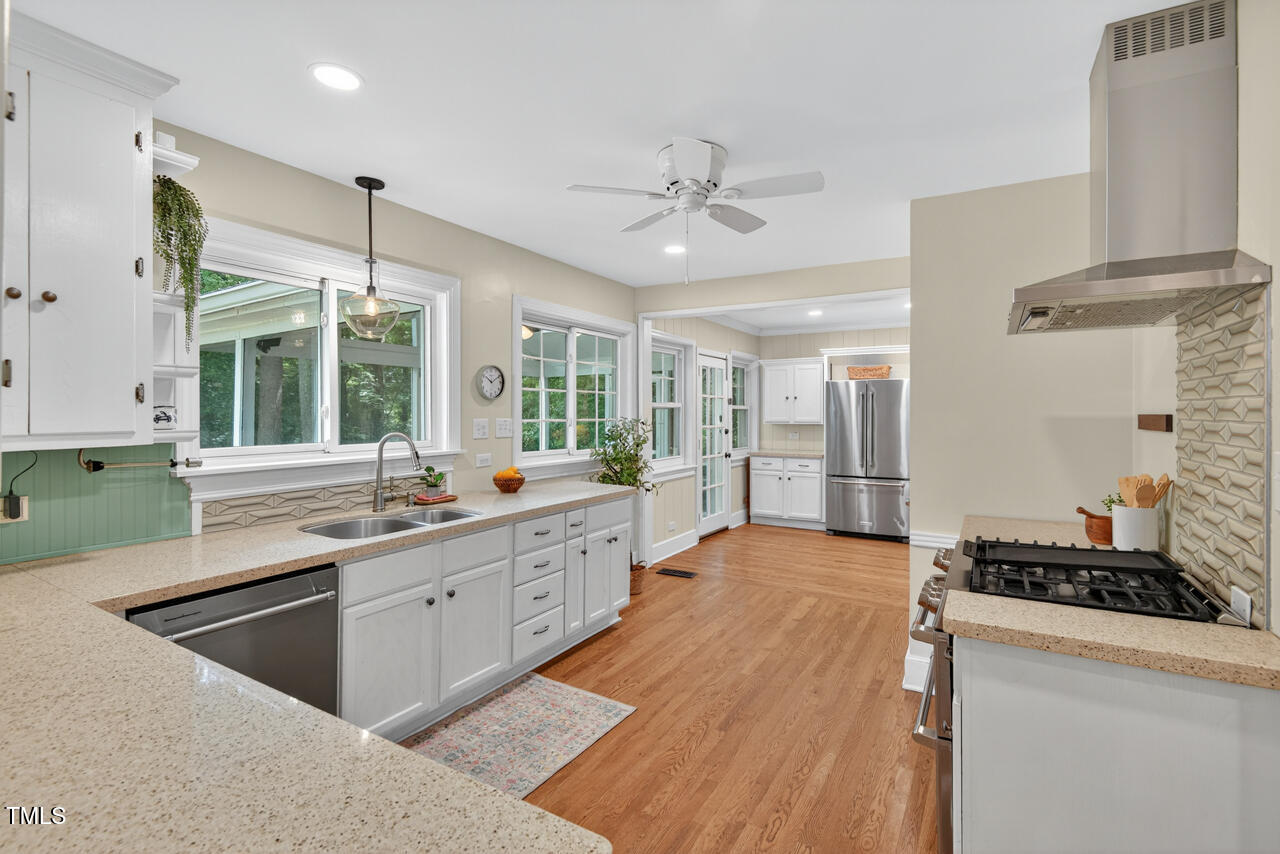 3535 Hope Valley Road Durham, NC 27707 - Photo 6 of 24 a large kitchen with stainless steel appliances a stove a sink dishwasher and a refrigerator with wooden floor