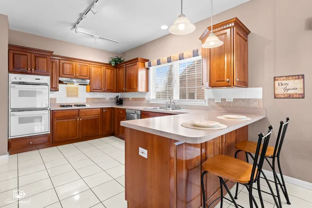 a kitchen with stainless steel appliances granite countertop a refrigerator and a sink