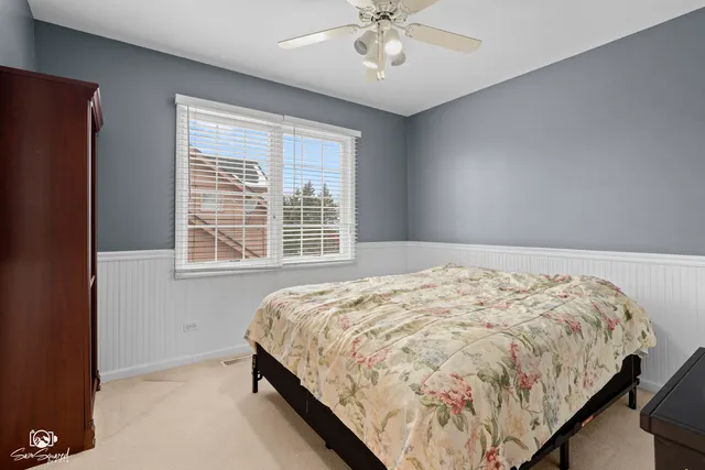 a bedroom with a bed and a ceiling fan
