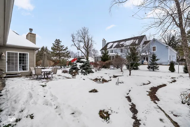 a view of a house with a yard covered with snow in front of house