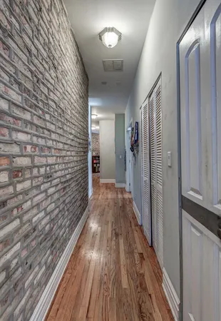 a view of a hallway with wooden floor and staircase