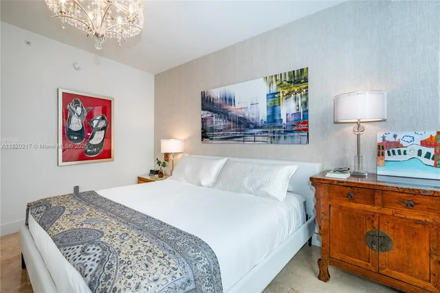 a bedroom with bed and a lamp on table