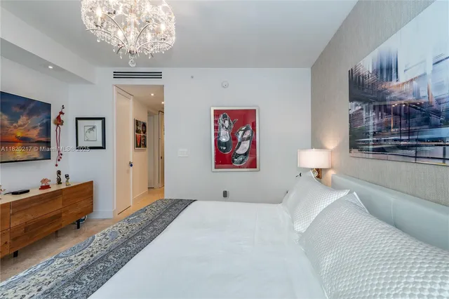 a bed room with a bed and a chandelier