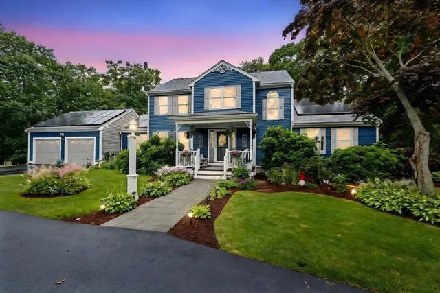 a front view of a house with yard and green space