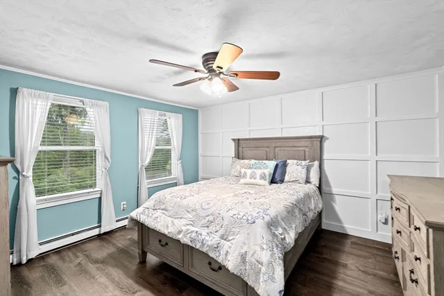 a bedroom with a bed and a large window with wooden floor