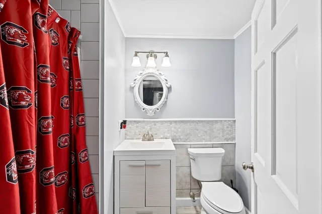 a bathroom with a toilet sink shower and mirror