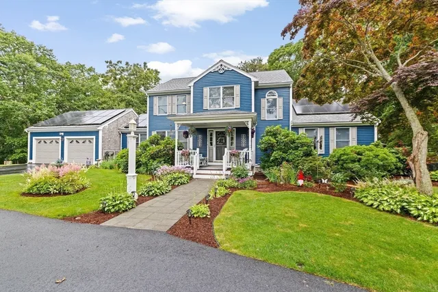 a front view of a house with a yard and potted plants