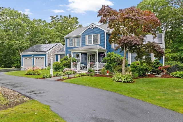 a front view of a house with a yard and potted plants