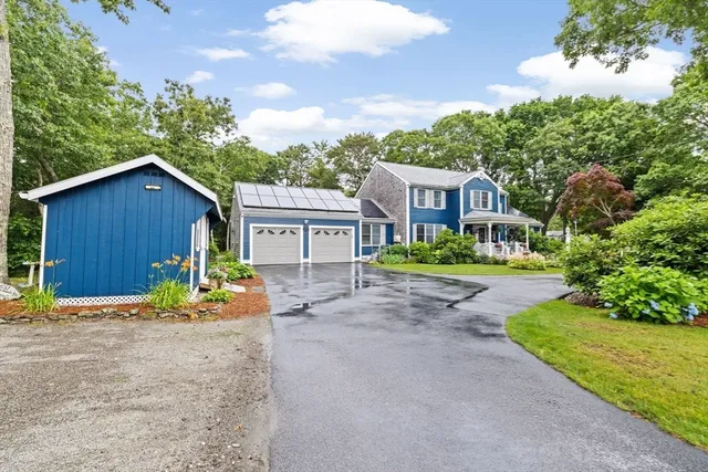 a view of a house with wooden fence next to a yard