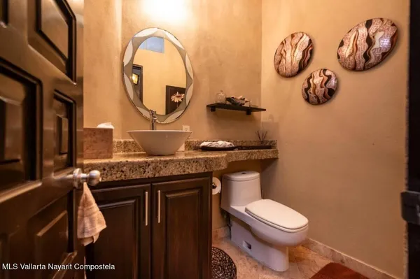 a bathroom with a toilet mirror and vanity