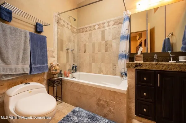 a bathroom with a tub sink and mirror