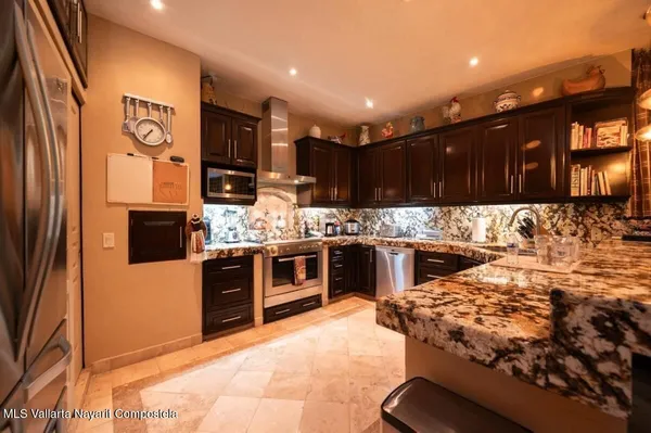 a kitchen with stainless steel appliances granite countertop a stove a sink and a refrigerator