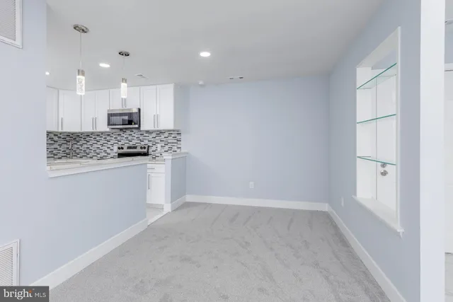 a kitchen with granite countertop white cabinets and stainless steel appliances